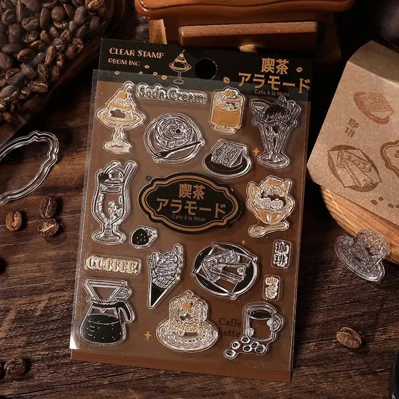 Förpackning med stämplar på tema kaffe. Det är kaffebönor strösslade på bordet. Clear stamps Coffee a la mode -från BGM - Tidformera