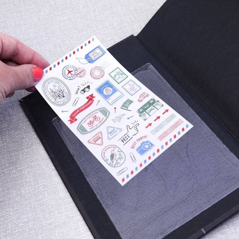 Självhäftande istoppsfickor A6 Pockets från 3L. En hand skjuter in ett ark i en plastficka som är fäst i en skrivbok. Tidformera