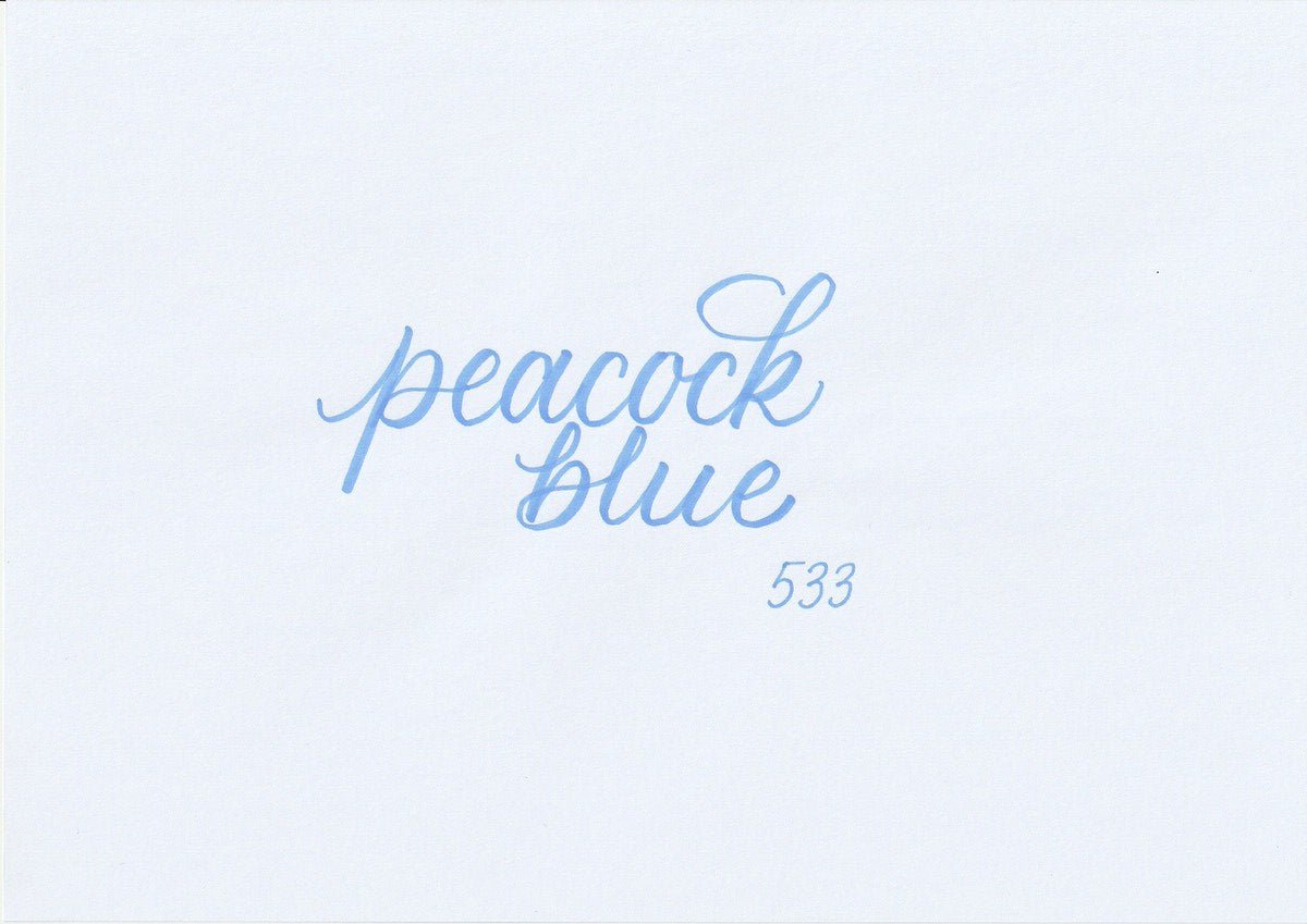 Handskriven text med ordet "peacock blue" i blå färg, skriven med ABT Dual Brush Pen i nyansen 533 Peacock Blue.