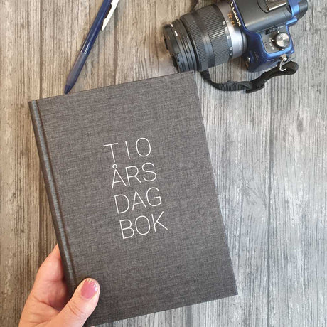 Svart 10-års dagbok med tygklädd pärm. Tidformera