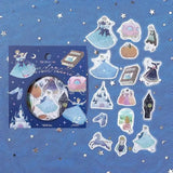 Flake stickers - Fairy Tale - Cinderella från BGM. Förpackning med klistermärken. Bredvid ligger motiv med askungen, slott, fe, bok, pumpavagn, elaka styvsystrarna och klackskor. - Tidformera