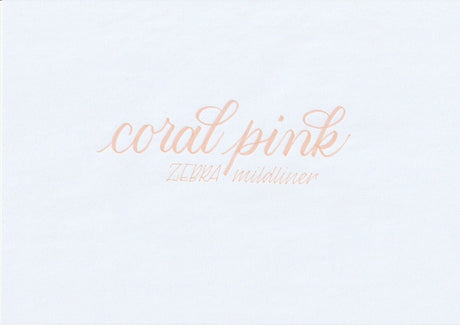 Handskriven text med orden "coral pink" och "ZEBRA mildliner" i korallrosa färg, skriven med Zebra Mildliner Brush Pen i färgen Coral Pink.