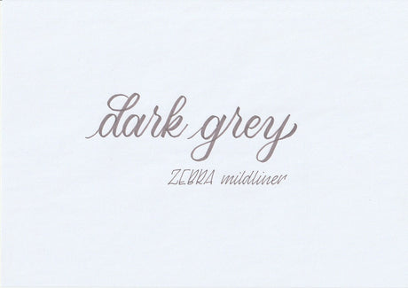 Handskriven text med orden "dark grey" och "ZEBRA mildliner" i mörkgrå färg, skriven med Zebra Mildliner Brush Pen i färgen Dark Grey.