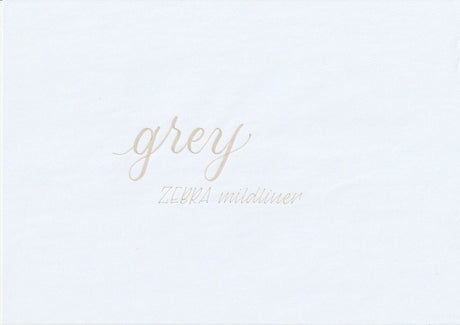 Handskriven text med orden "grey" och "ZEBRA mildliner" i grå färg, skriven med Zebra Mildliner Brush Pen i färgen Grey.